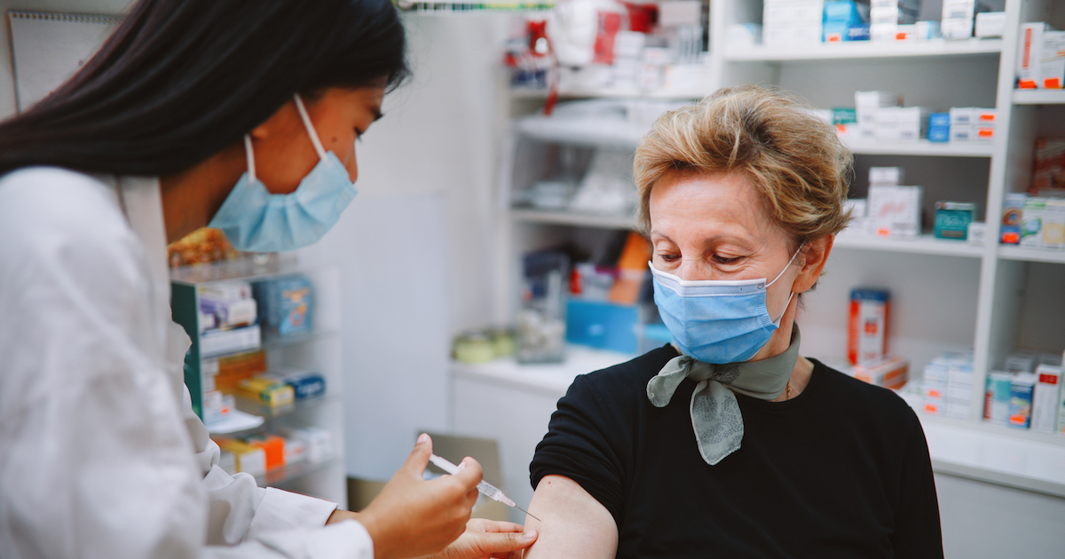 
  Pharmacist giving a person an injection 
