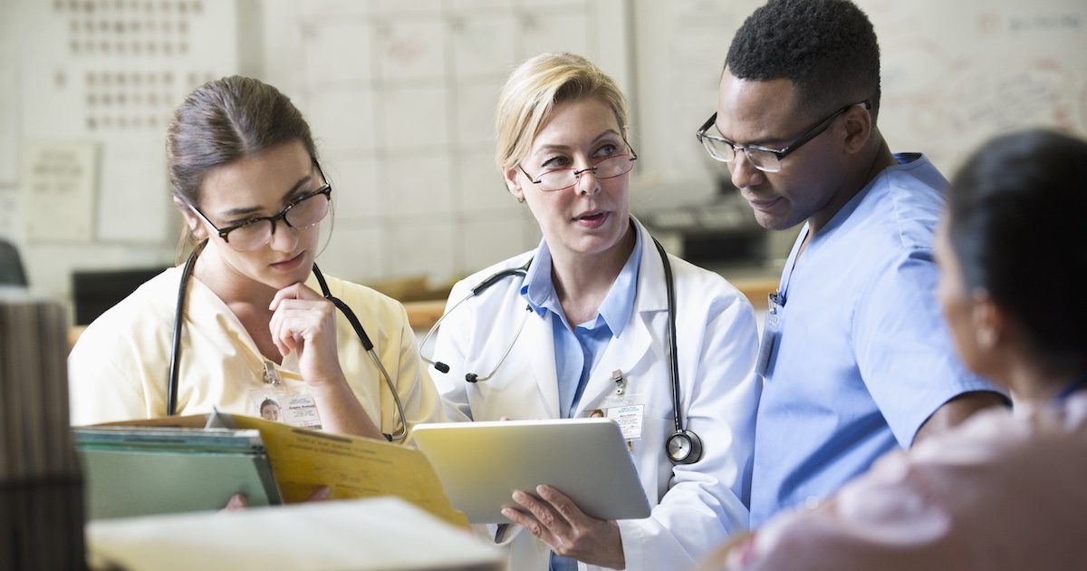 
  Healthcare professionals reviewing patient chart on a tablet computer
