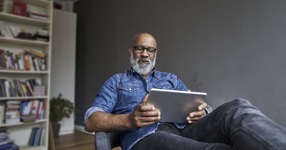 
  Person sitting in a chair while looking at a tablet
