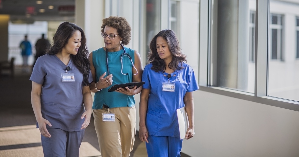 
  Three healthcare professionals conversing 
