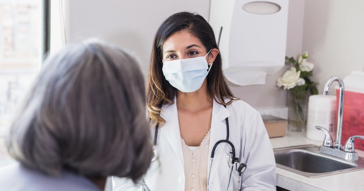 
  Healthcare provider sitting with a patient in the clinical setting
