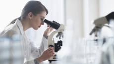 Technician looking into a microscope
