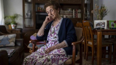 Older woman sitting in her living room pensive and depressed