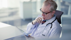Healthcare provider sitting at a desk and looking at a chart