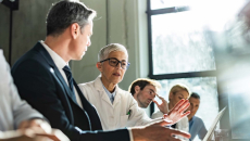 Healthcare providers and business people sitting a room together
