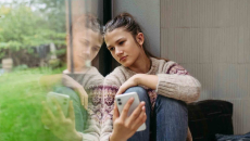 Person sitting next to a window who looks depressed