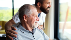 Patient in a chair with a healthcare provider standing next to them