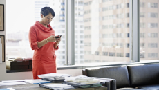 Person standing in an office and looking at their phone