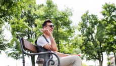 Blind person sitting on a bench in a park