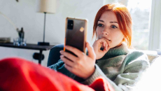 Person sitting on a couch and looking at their mobile phone