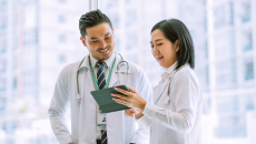 Doctors reviewing a patient file on a digital tablet