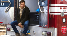 Jeremy Renner sitting on the back of an ambulance