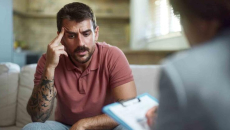 Person who looks upset sitting with a therapist