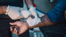 Patient with wounded wrist being patched up with bandage