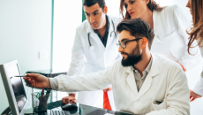 Four healthcare providers looking at a computer