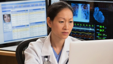 A doctor analysing a report on a desktop computer