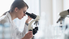 Clinician looking through a microscope