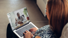 Patient interacting with healthcare professional via laptop