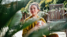 Person sitting outside while drinking a cup of coffee