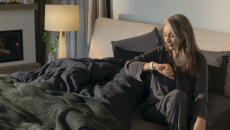 Fitbit user checks smartwatch before getting out of bed