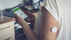 A patient checks their blood glucose level through a smartphone app