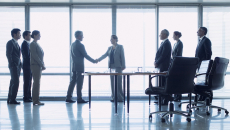 Business representatives shake hands to close a deal