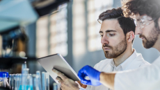 Lab researchers using a digital tablet in their research
