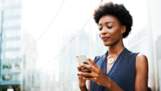 Women standing on a street looking at her phone