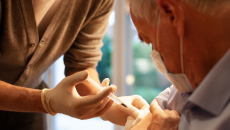 Healthcare practitioners administering injection to patient