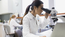 Healthcare professional looking into a microscope