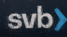 The Silicon Valley Bank (SVB) logo is seen through a rain covered window in front of the SVB headquarters.