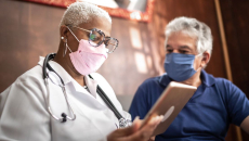 Doctor talking to senior male patient in a home visit