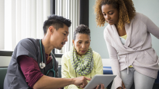 A provider showing a patient and their family member information on a tablet