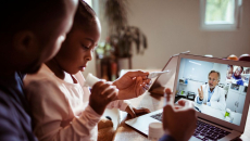 A father and a daughter doing a telehealth visit