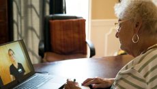 An older woman talks to a provider via telehealth