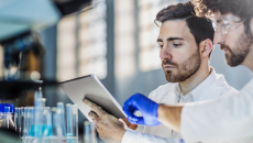 Two people in lab looking a tablet