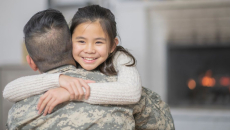 Soldier in uniform with his back turned while hugging someone not in uniform