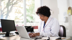 Healthcare provider sitting in an office at a desk with a computer on it