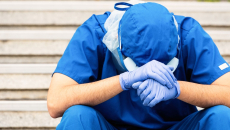 Healthcare provider sitting with their head in their hands