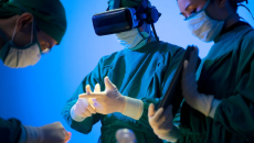 Three healthcare providers in the surgery setting with one wearing a virtual reality headset