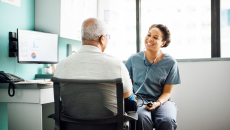 Healthcare provider sitting with a patient near a desk