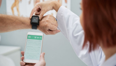 A doctor synchronising a patient's smartwatch with their mobile app