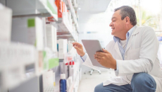 A pharmacist doing an inventory in a drug store using a digital tablet