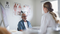 A senior patient in an in-person consultation with a doctor in a clinic
