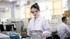 A lab researcher holding a digital tablet