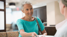 A woman handing her insurance card to a provider