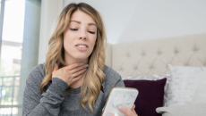A person talking on a video chat on a phone about a sore throat