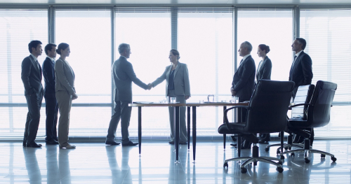 Business officials shake hand in closing a deal