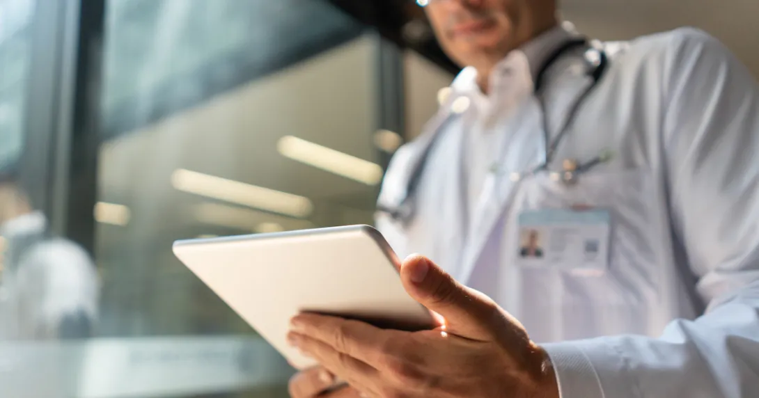A doctor reviewing a patient's file on a digital tablet
A doctor reviewing a patient's file on a digital tablet