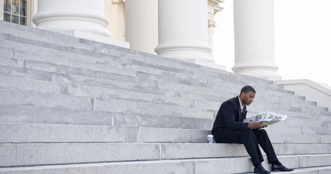 Man sitting on court building steps
Man sitting on court building steps